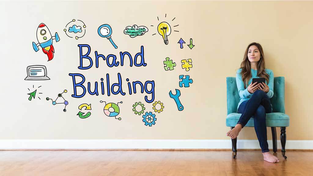Women sitting in a chair against the wall having Brand Building written on it