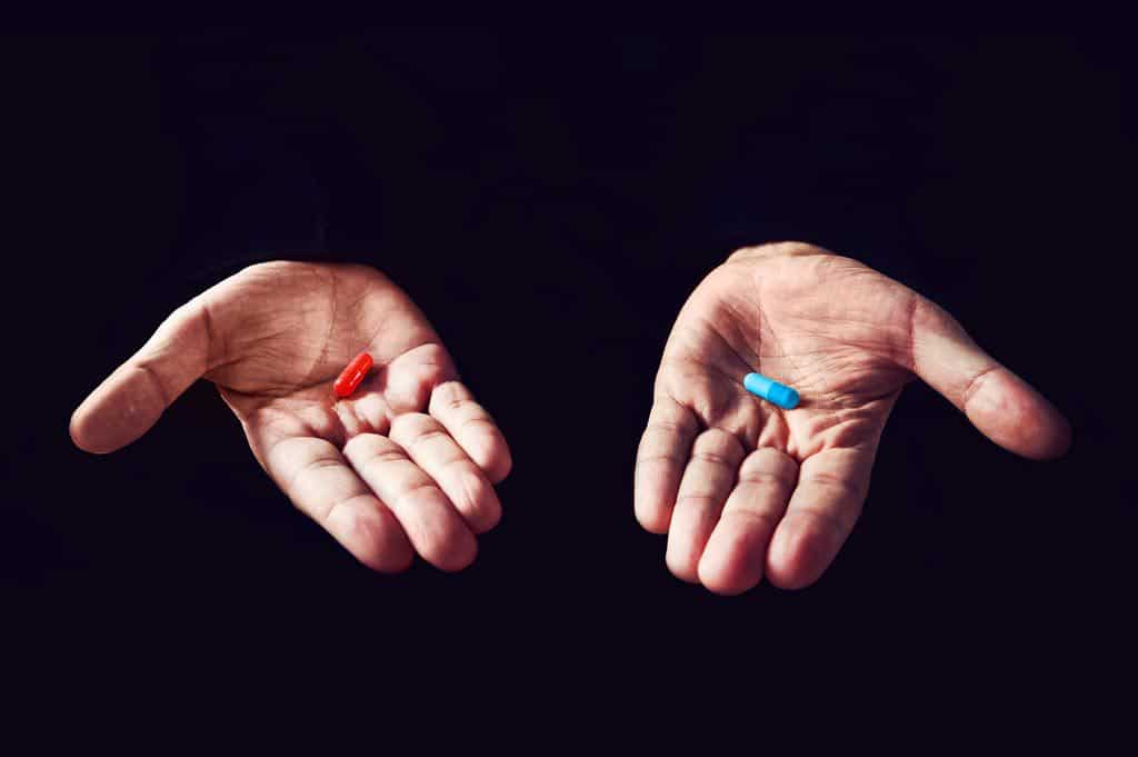 blue and red capsules in each palm